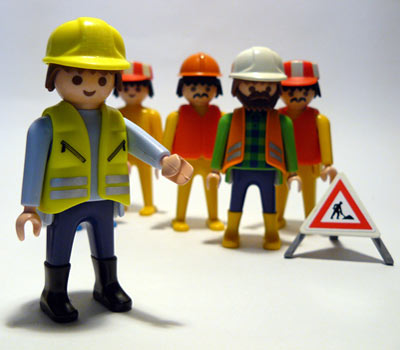 5 playmo veiarbeidere foran varselskilt 