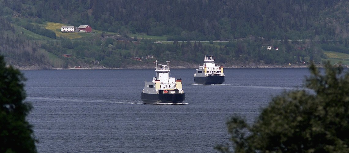 to ferjer som krysser en fjord hver sin vei