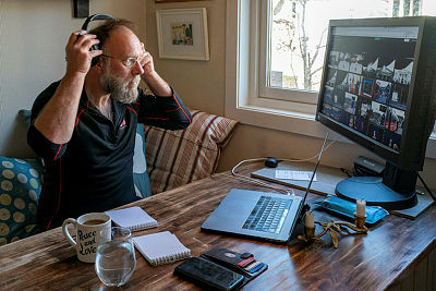 Mann sitter på sengekanten foran PC