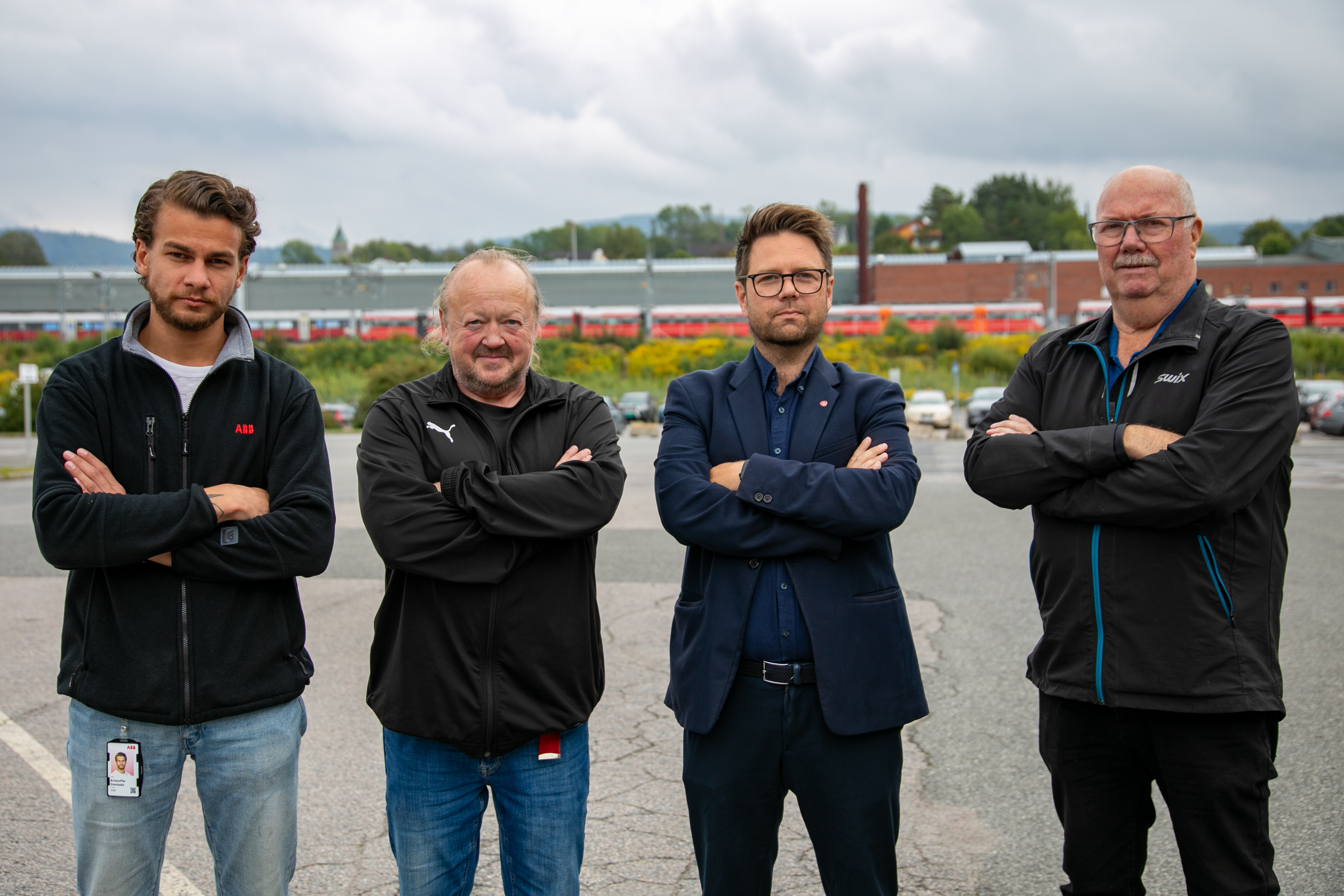 fire menn med armer i kors