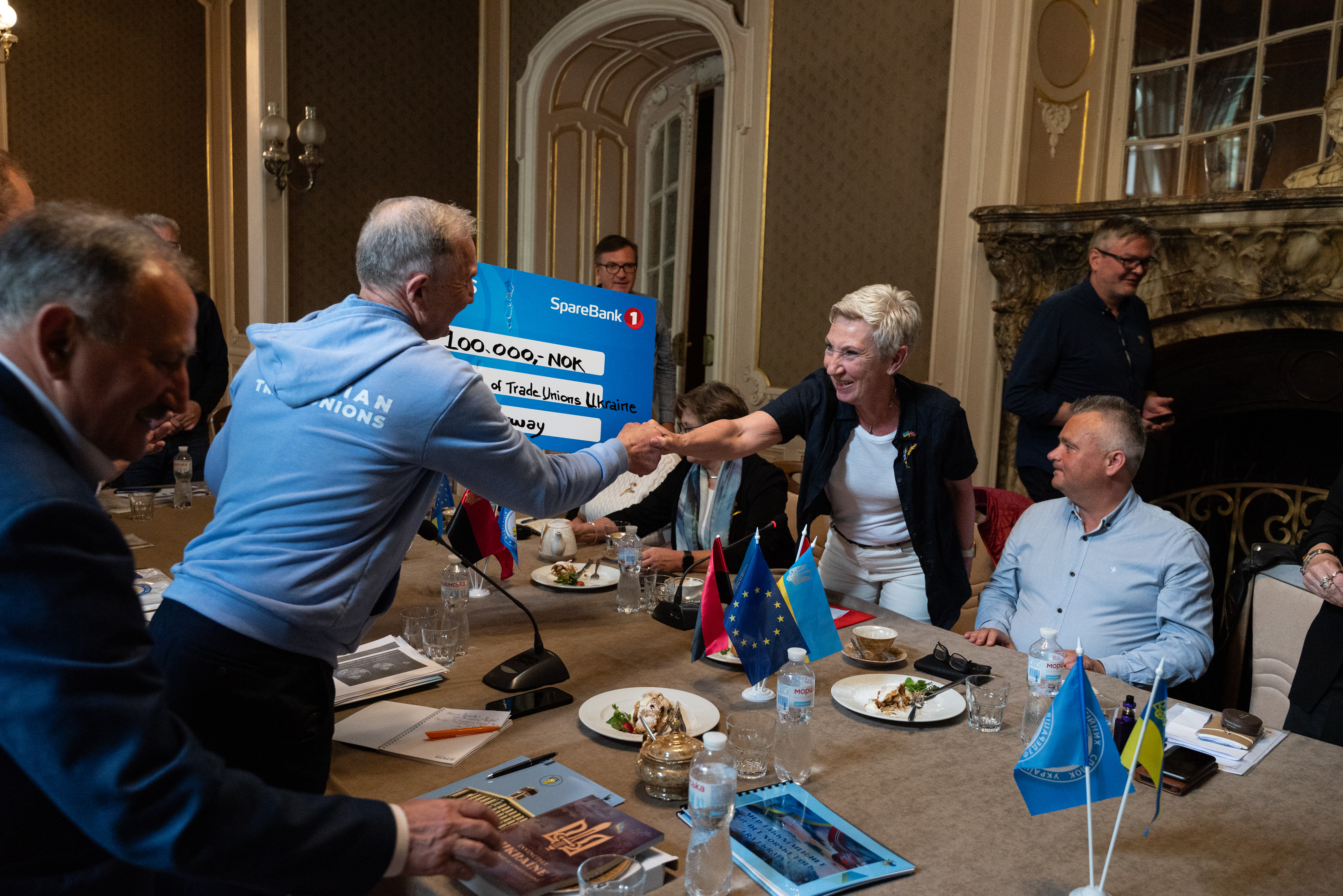 LO-leder Peggy Hessen Følsvik overleverer en sjekk til ukrainsk fagbevegelse. Foto.