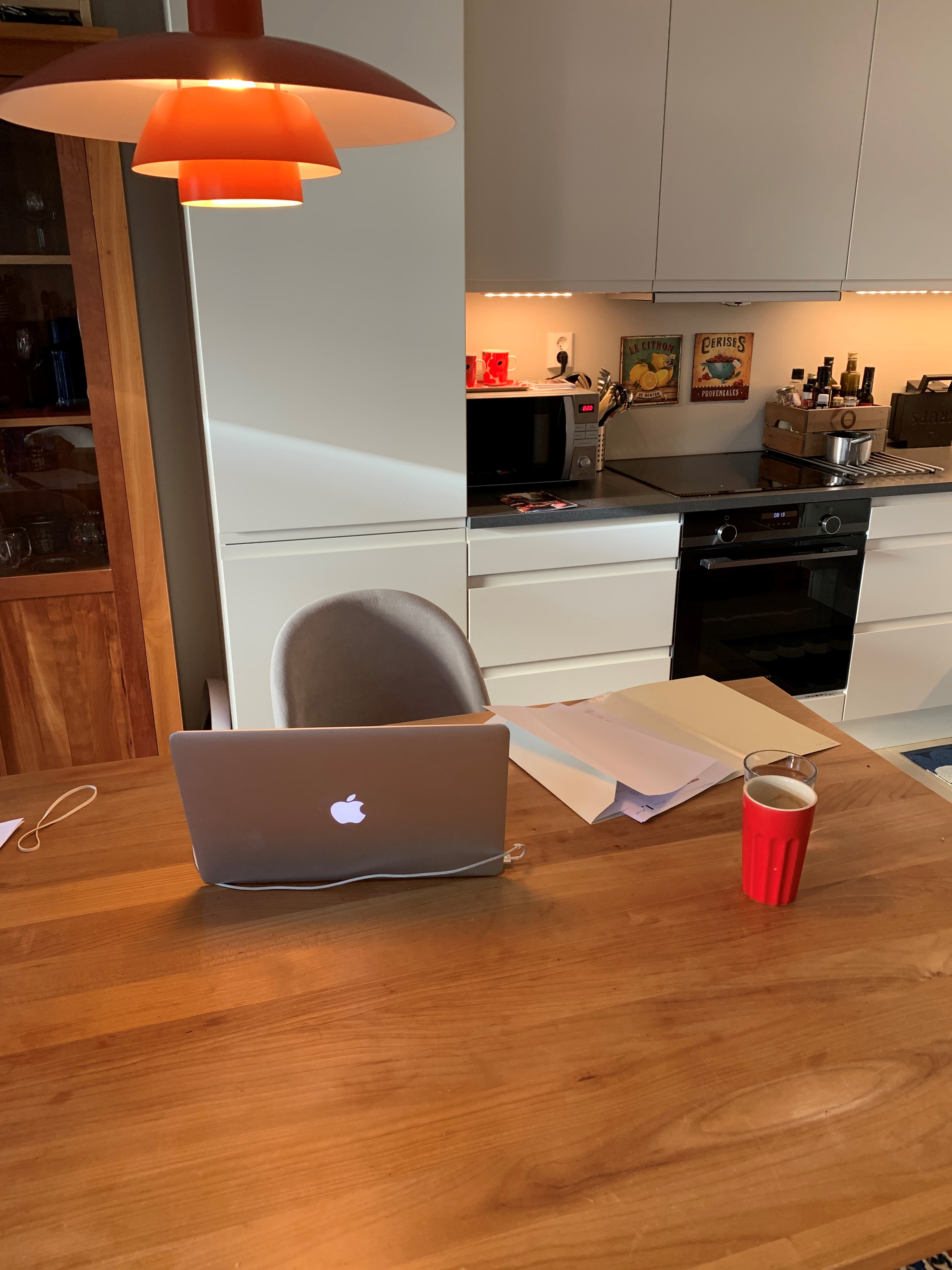 Kjøkkenbord med datamaskin og papirer