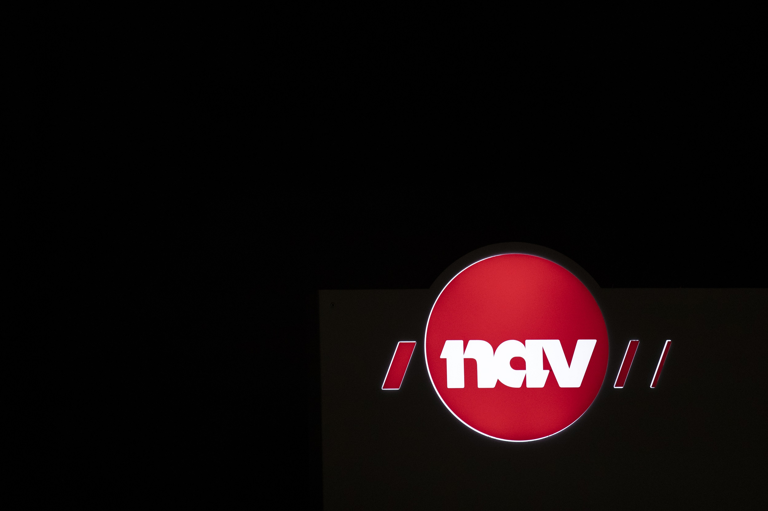 Nav-skilt i kveldsbelysning.