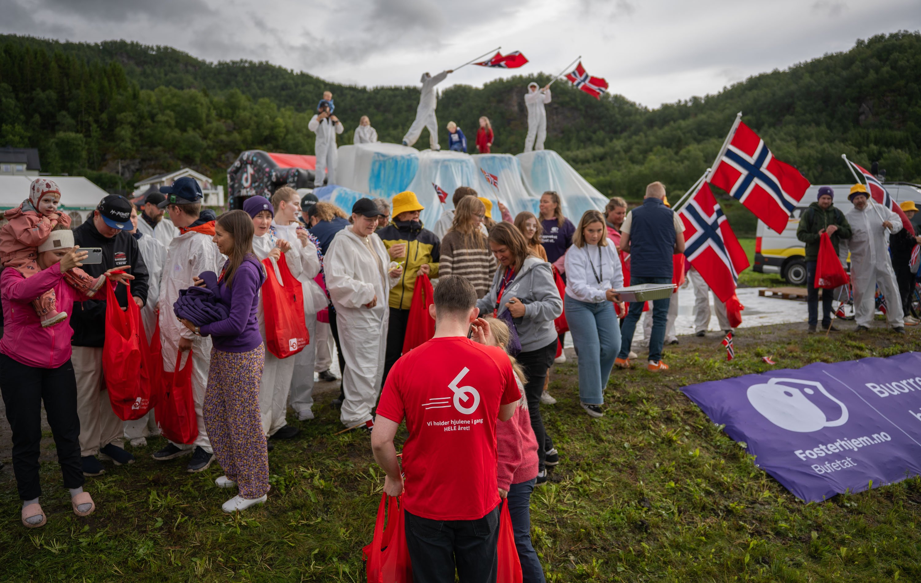 Flere mennesker samlet med flagg, noen på en rundball