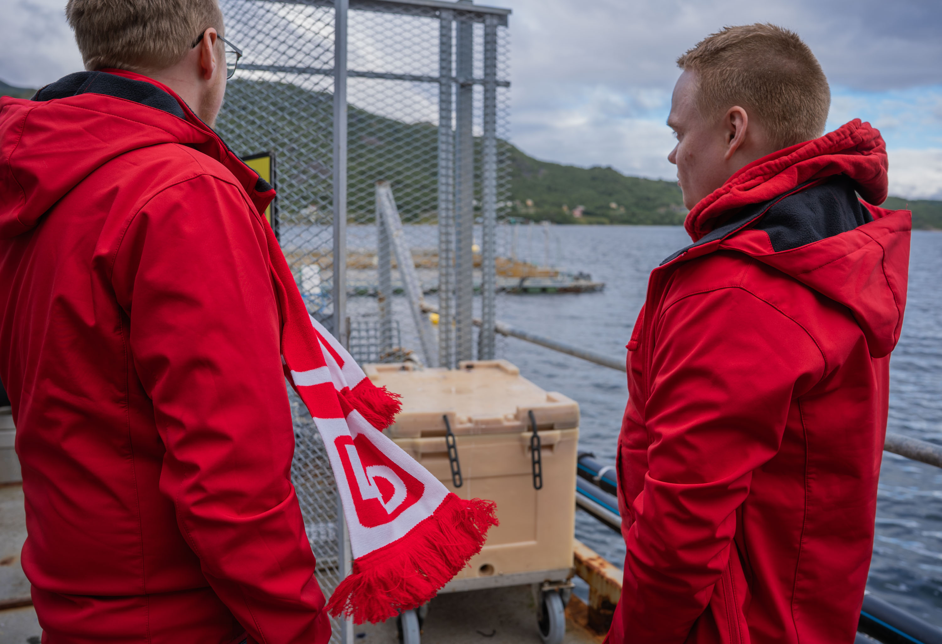 To menn i rød jakke på en båt