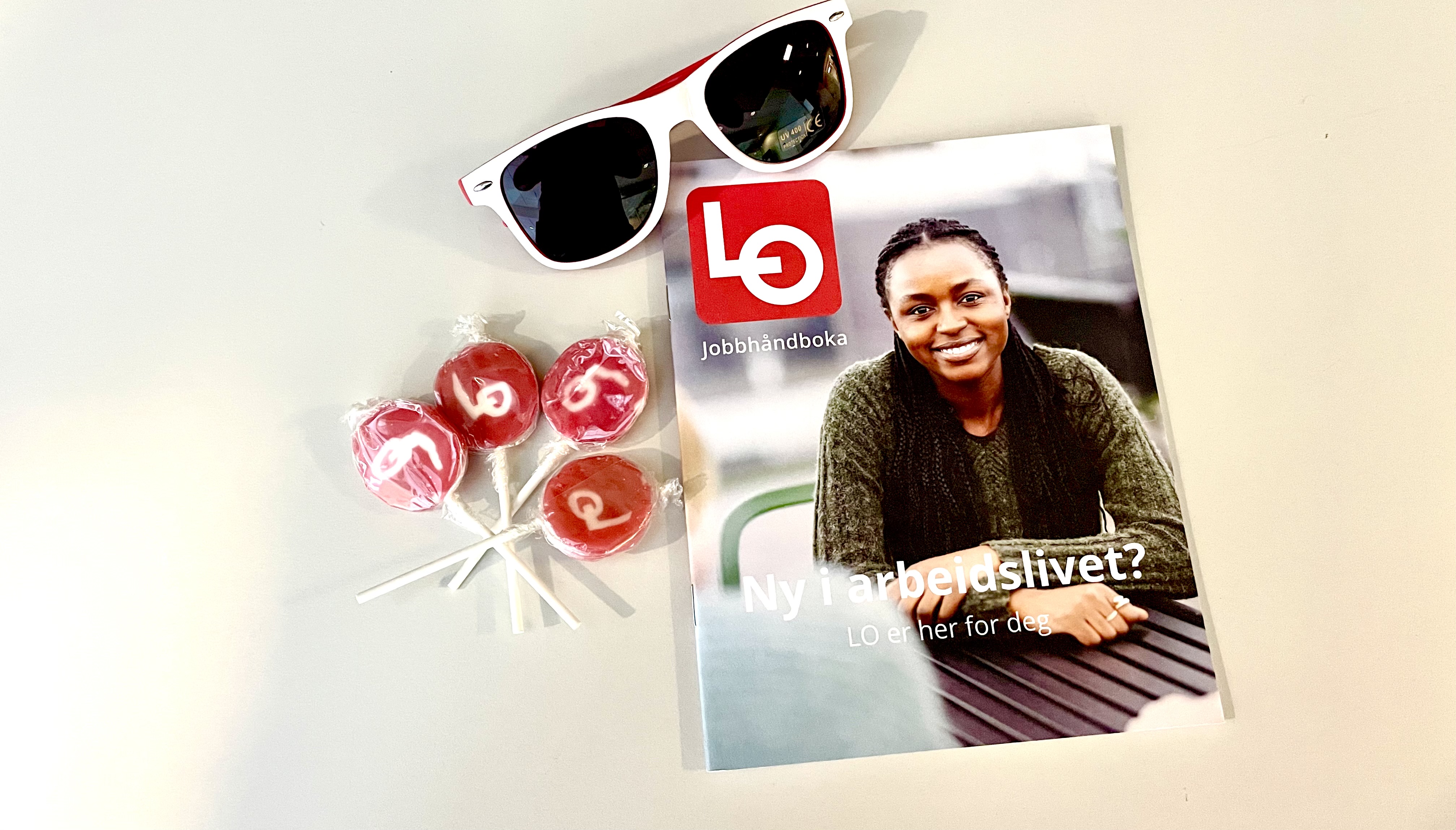 LOs jobbhåndbok, kjærlighet og LO-solbriller på et bord
