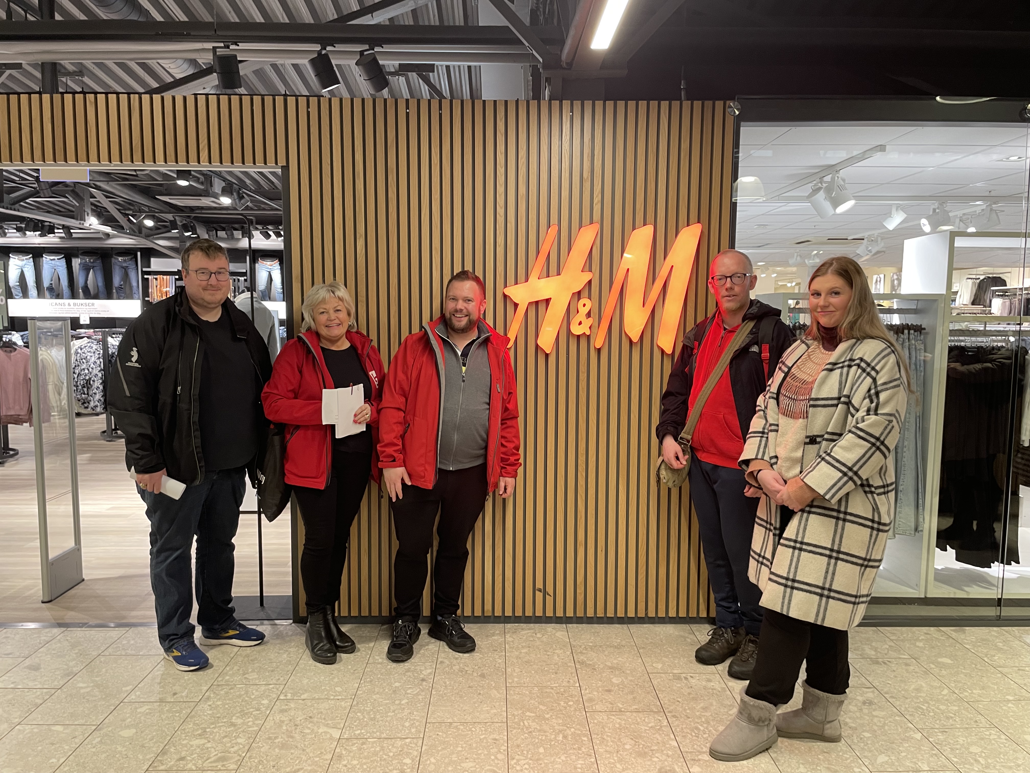 Fem blide HK/LO-medlemmer i forkant av H&M-butikken på Down Town