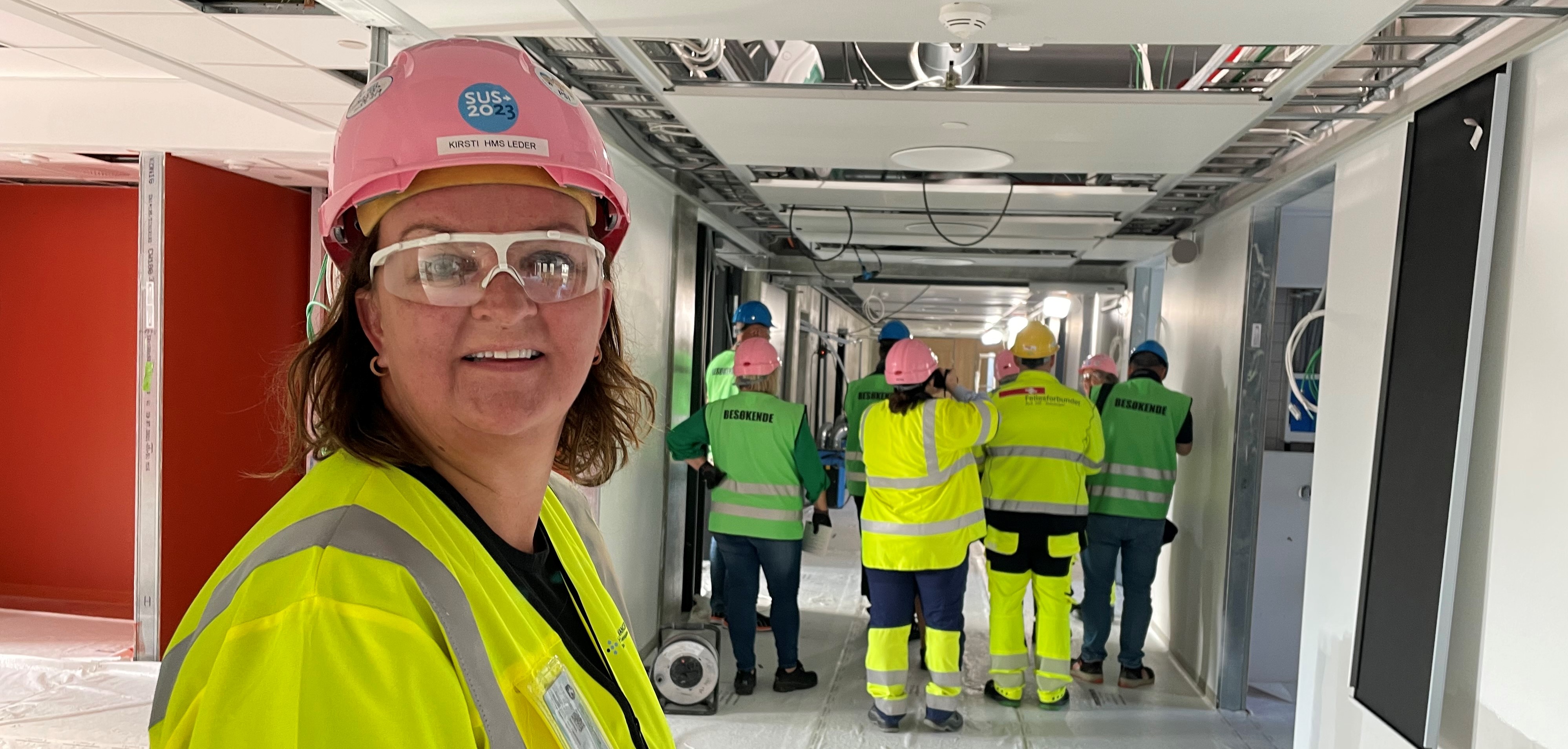 Smilende ansatt i byggelokaler