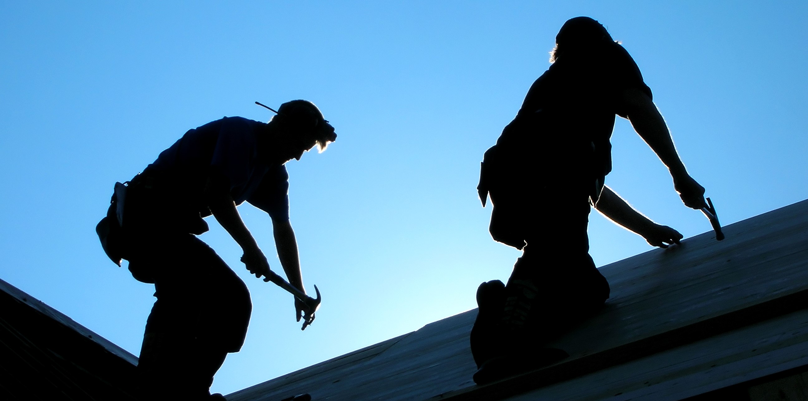 Usikrede tømrere arbeider på tak.