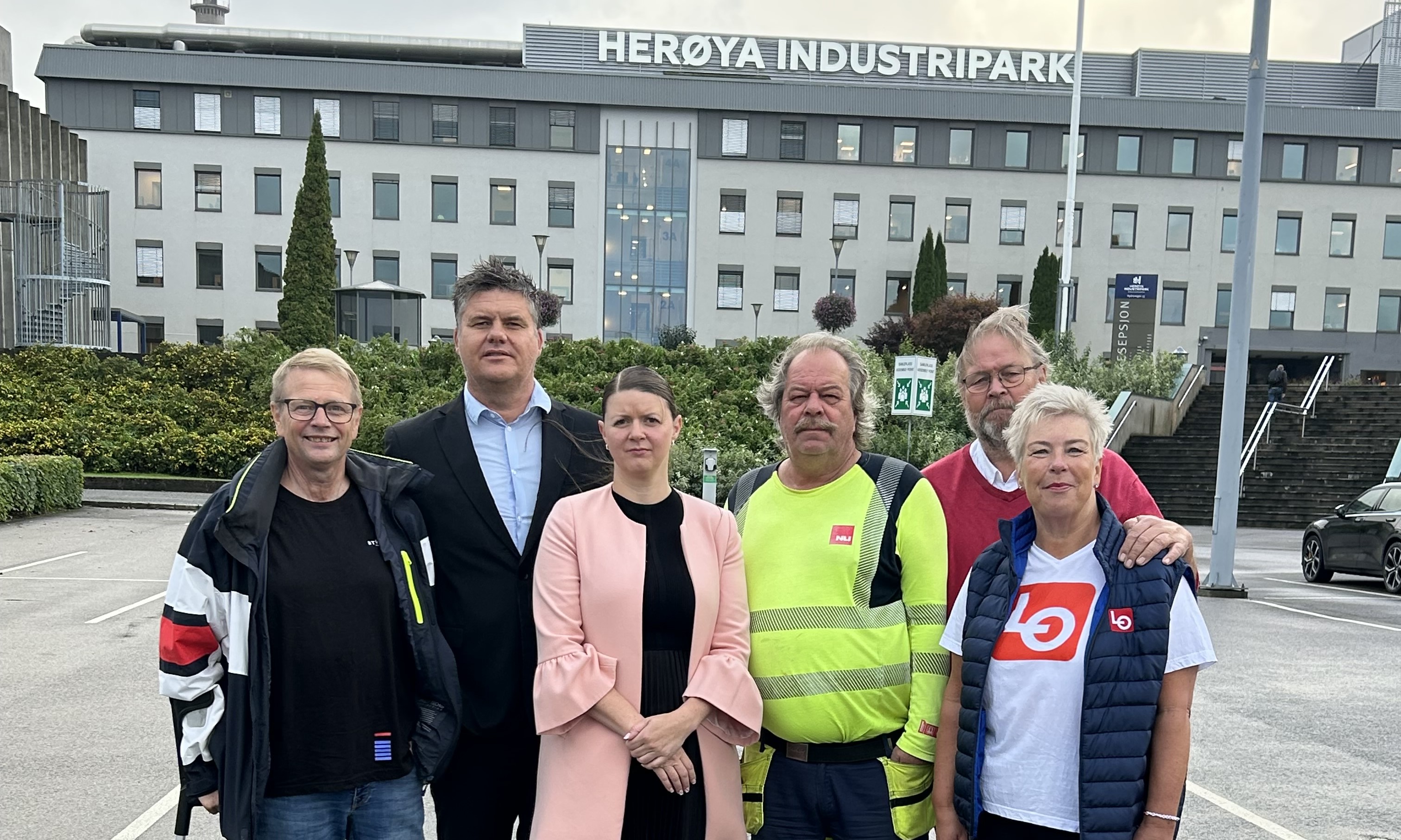 en gruppe menn og kvinner foran Herøya Industripark