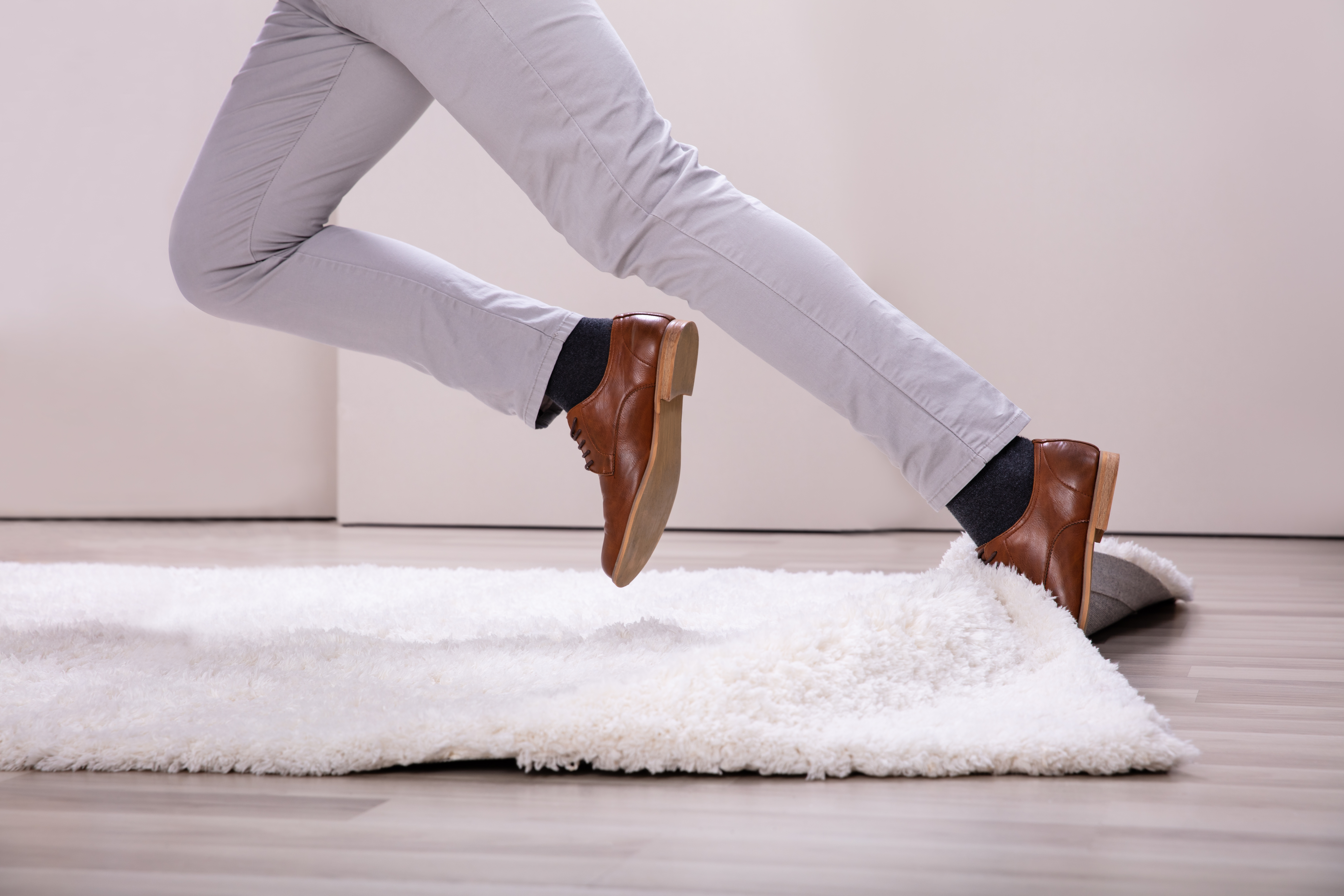 Ben som snubler i et teppe