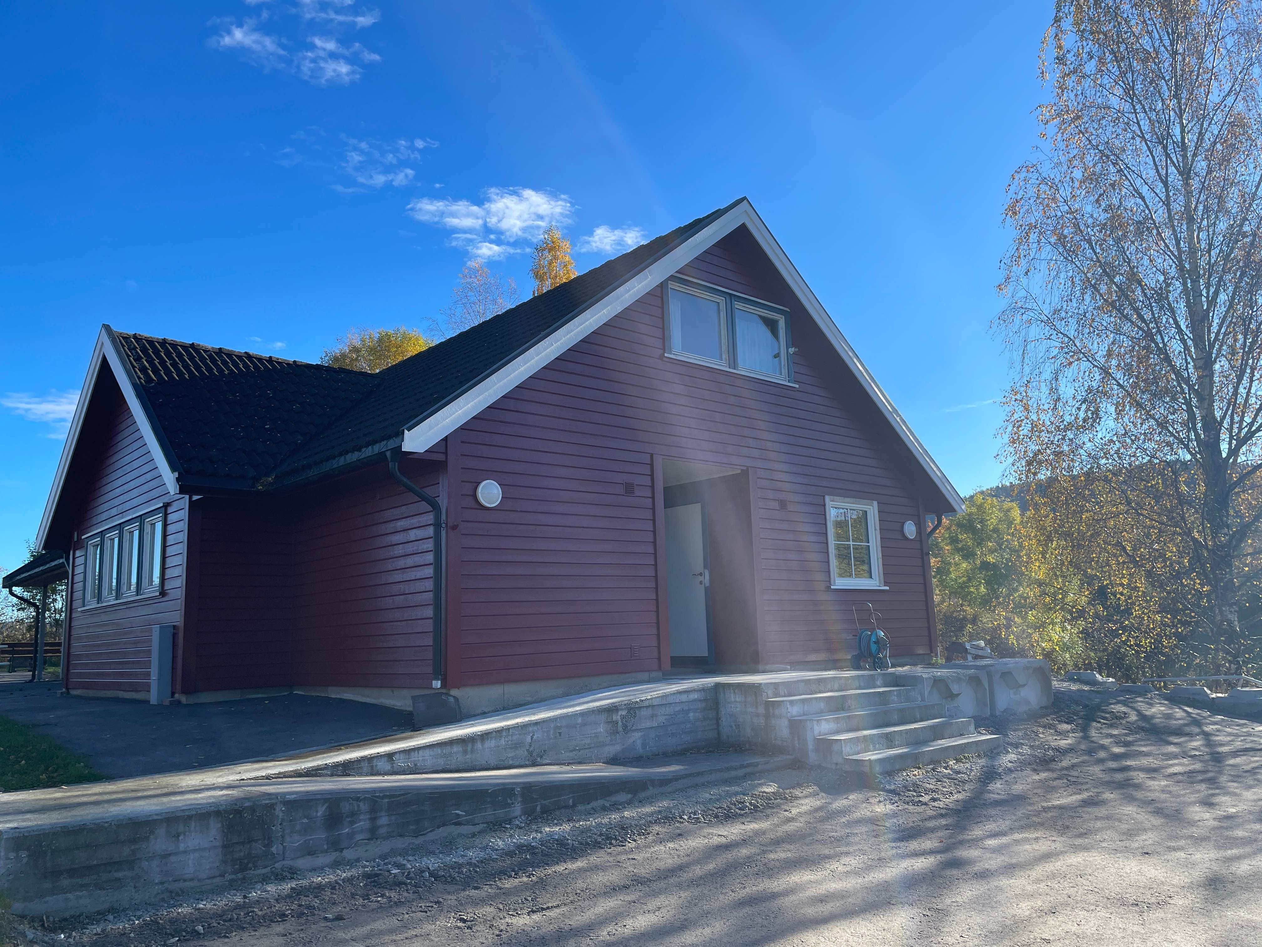 Hovedhuset på Hanes feriekoloni fra gårdsplassen. Et flott nymalt hus i rødt.