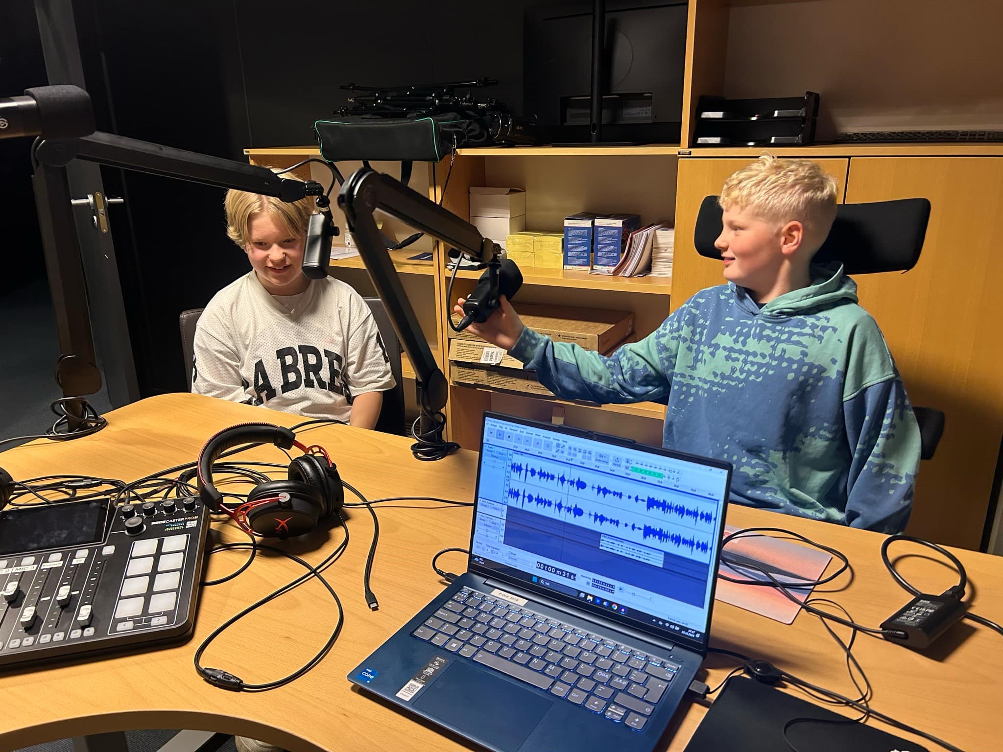 Gjestene Tom Bjerkholt-Thomassen og Odin Hofvander sitter bak mikrofonene i studio.
