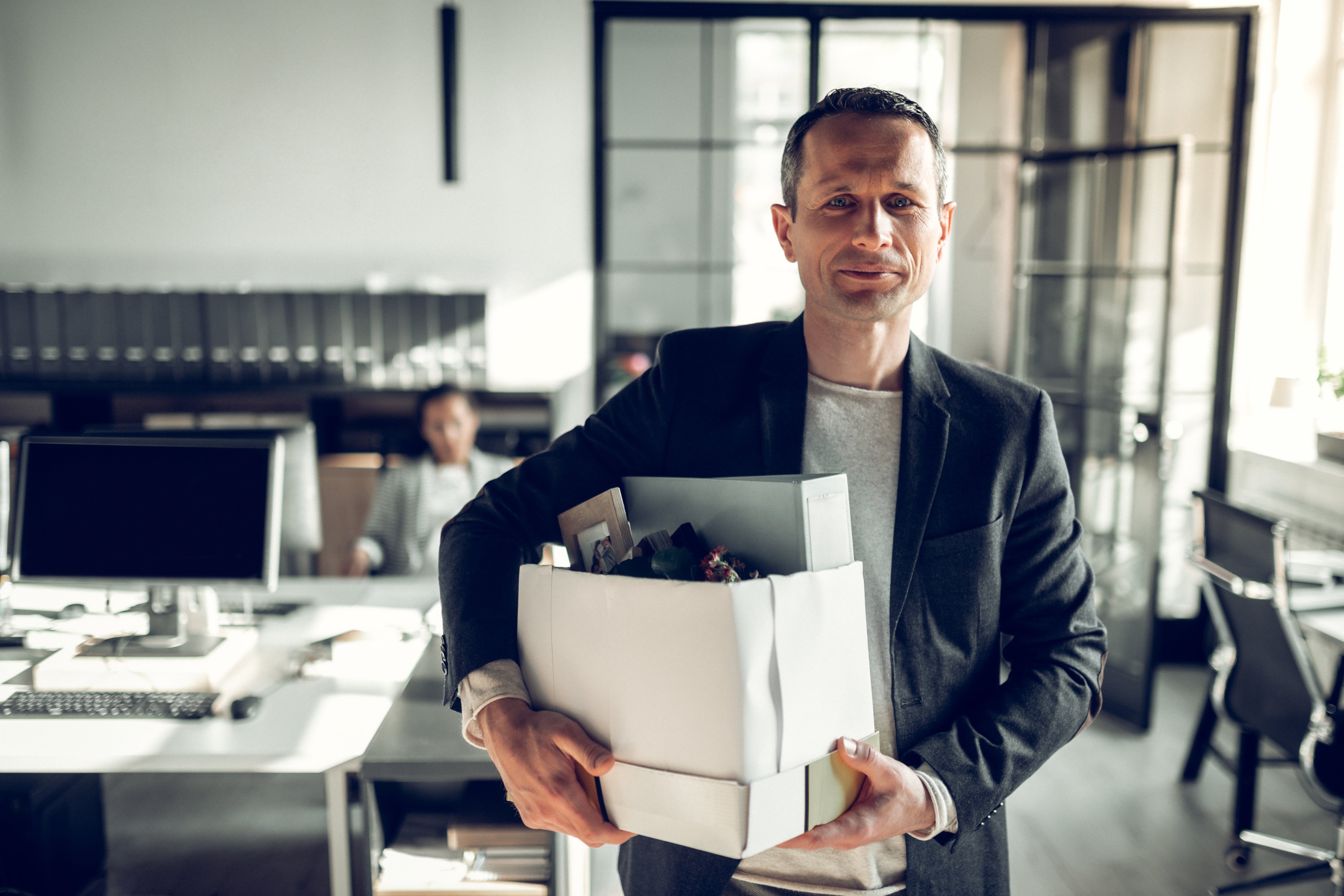 Ansatt forlater kontoret med sine personlige eiendeler i en kasse