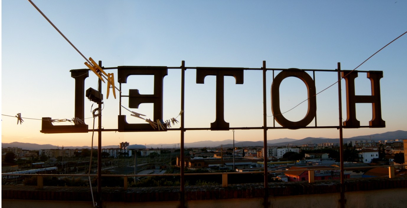 skilt med tekst hotell sett bakfra mot blå himmel