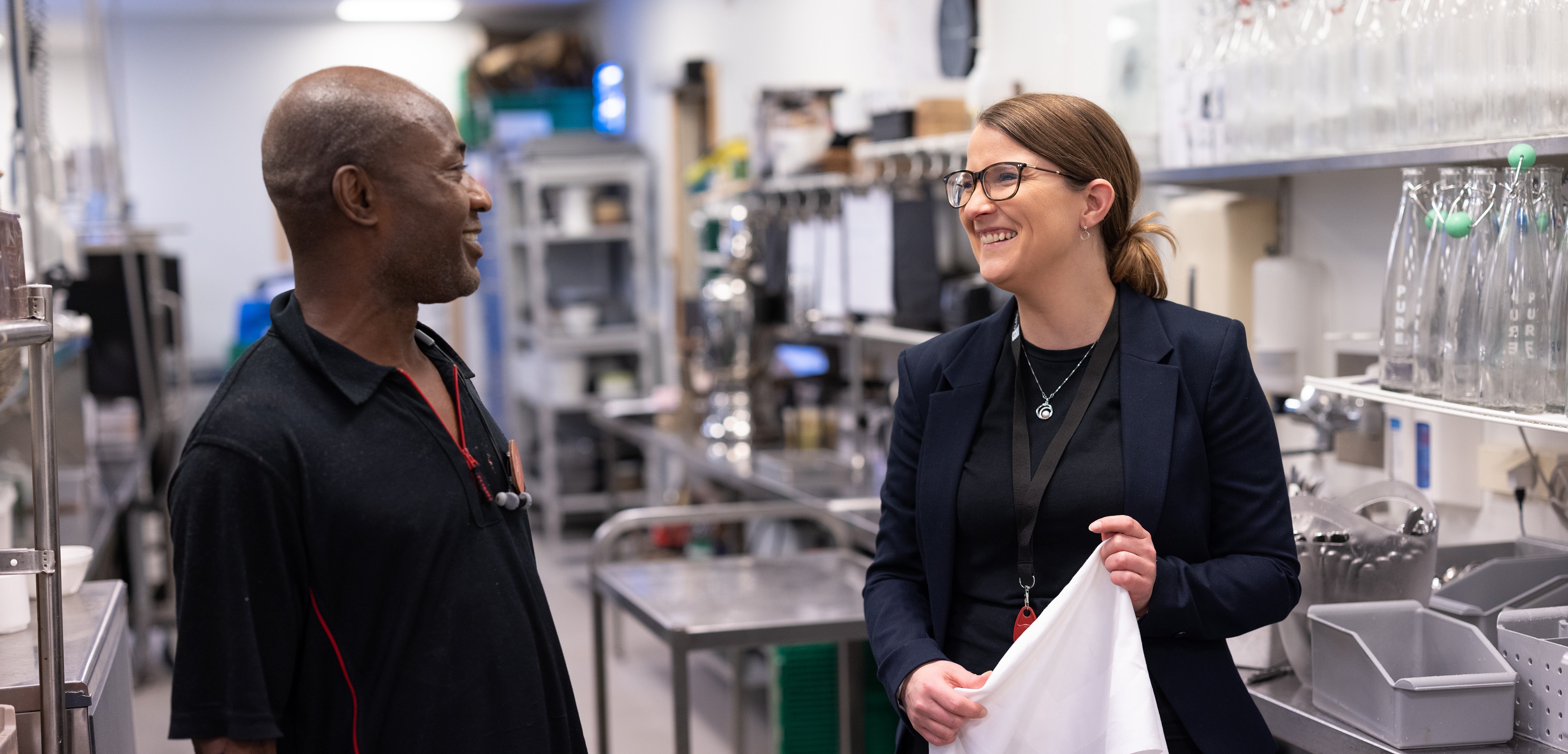 Bilde av to ansatte i samtaler med hverandre på en hotellarbeidsplass