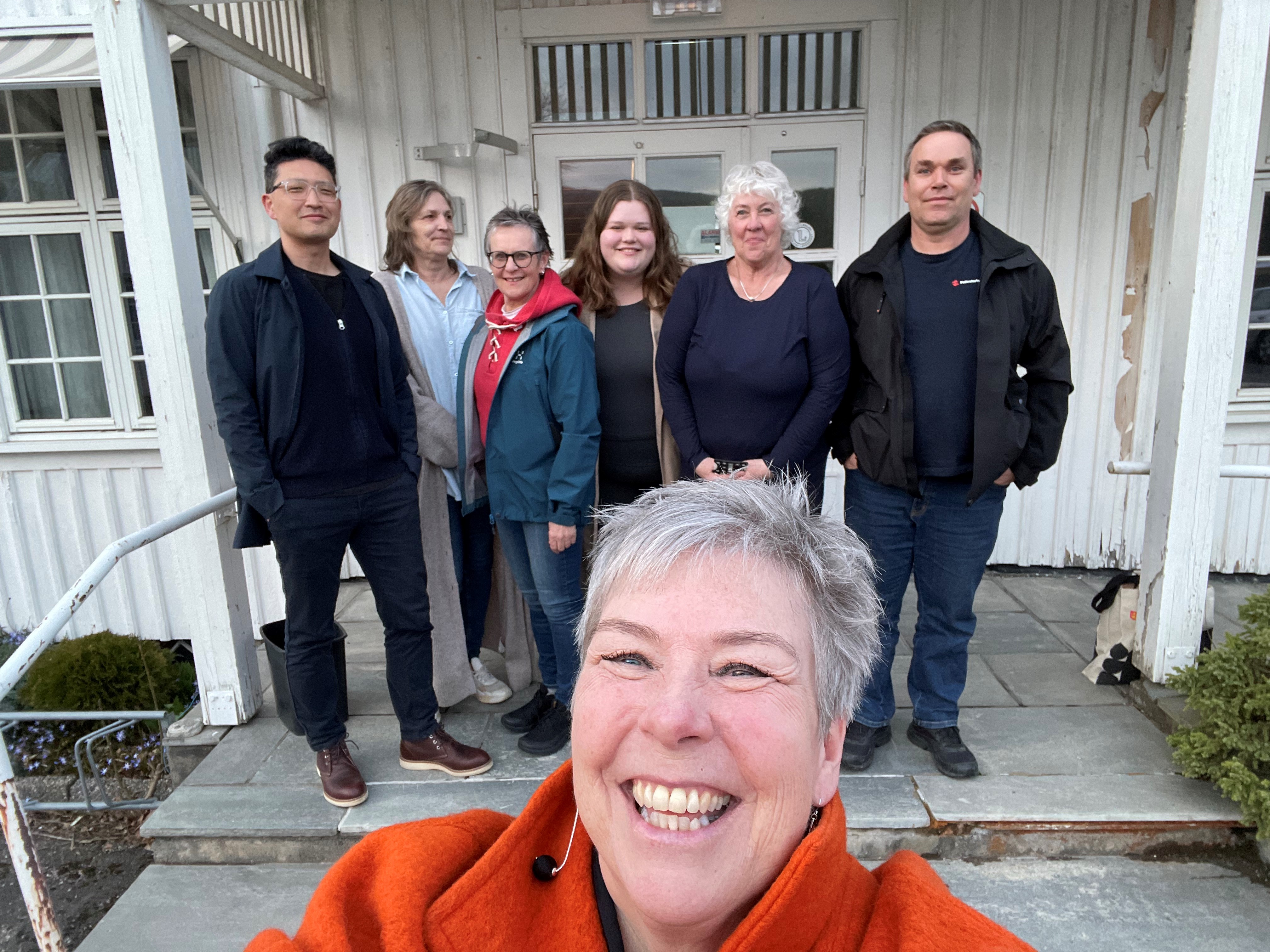 menn og kvinner foran hus