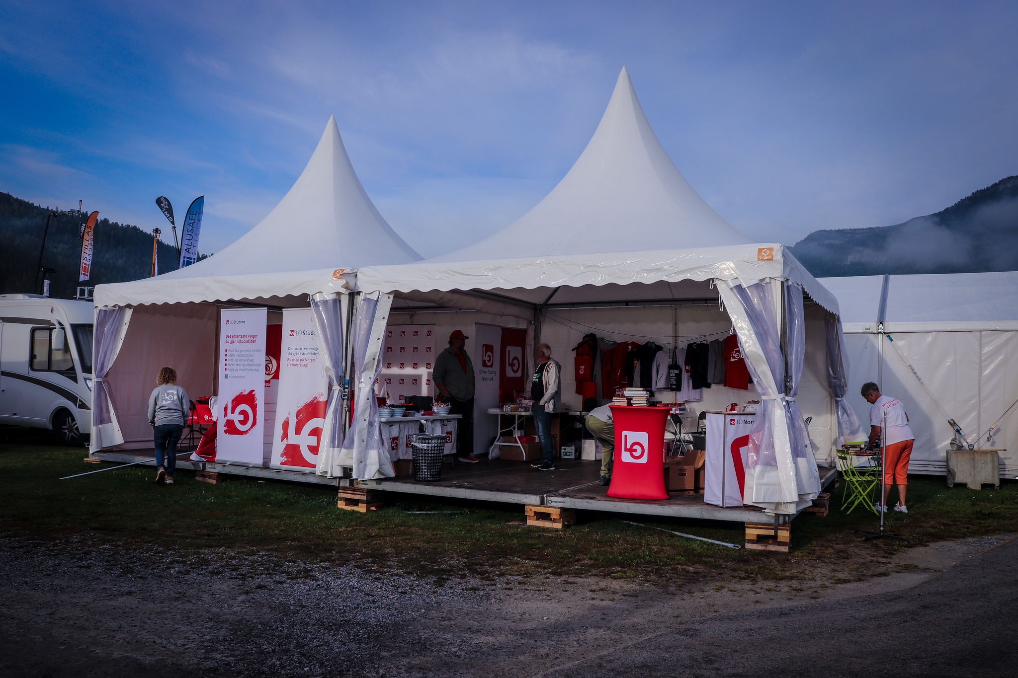 LOs stand på Dyrskun 2023. Teltet i bakgrunn og folk som rigger standen klar.