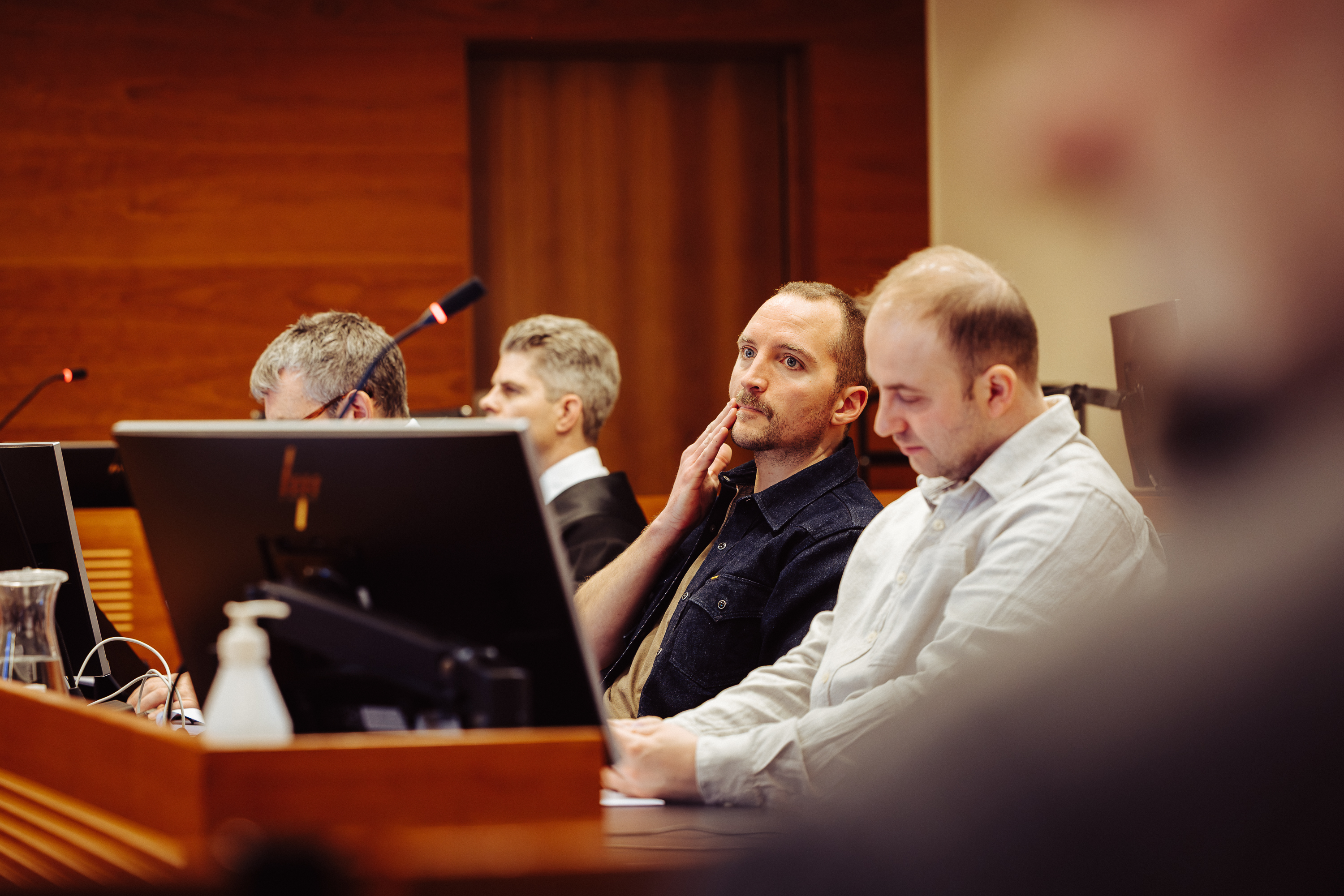Sykkelbud Espen Landgraff sammen med sitt juridiske team i rettsal. Foto.