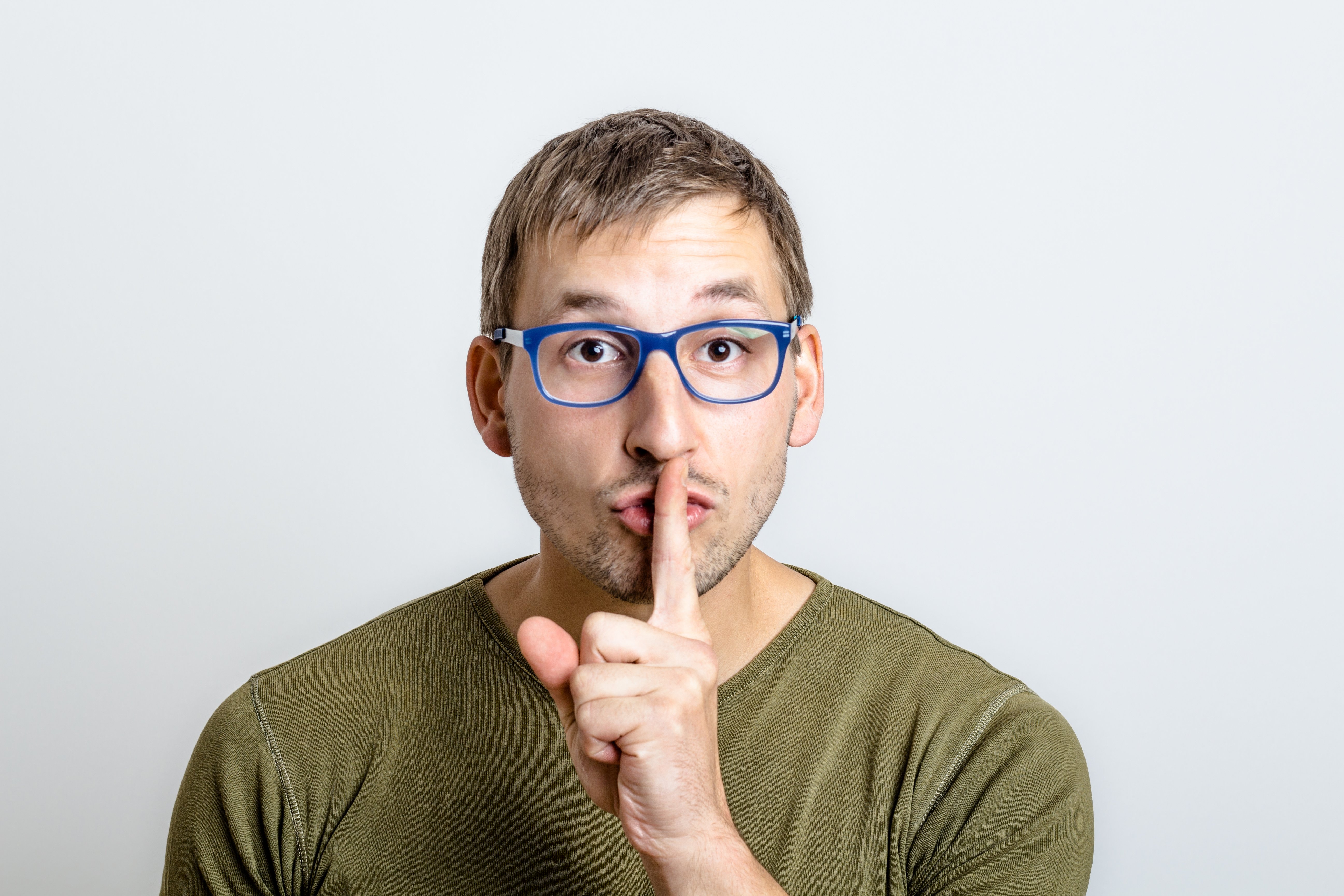 Hysj - mann med finger for munnen