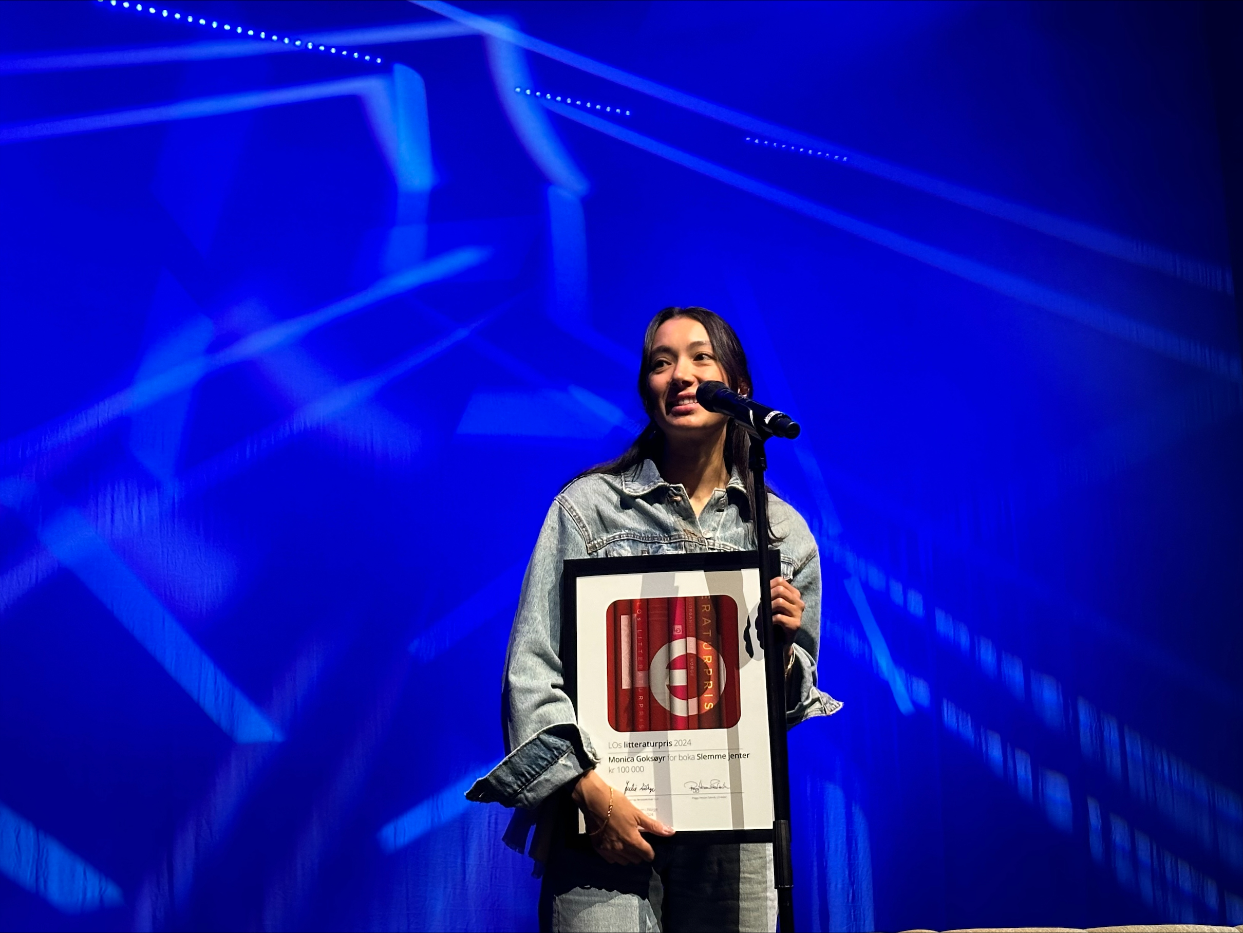 prisvinner Monica Goksøyr mottar pris på scenen. Foto.