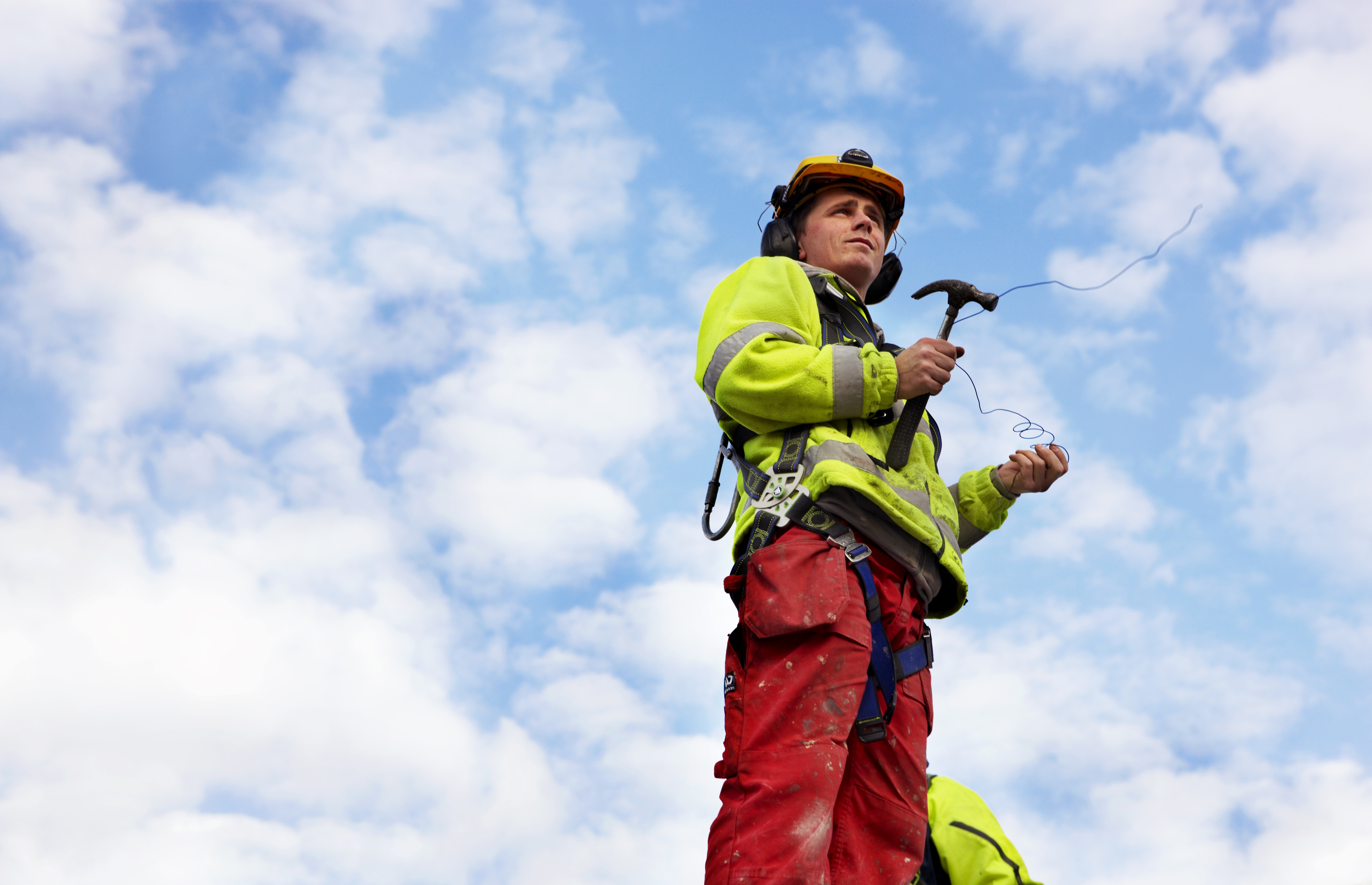 LO-lederen snakker med en snekkerlærling på arbeidsplass. Foto.