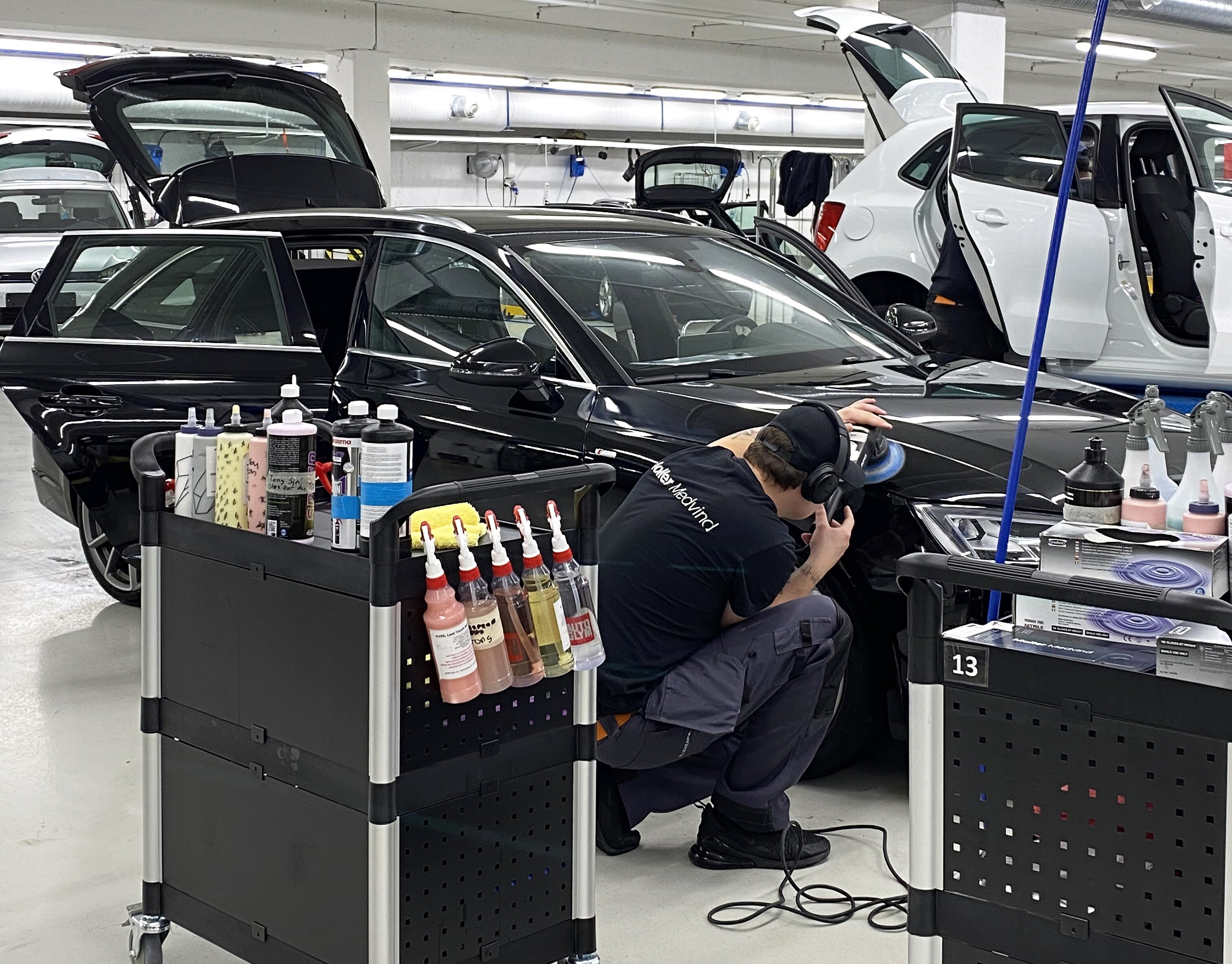 Bilde av en mann som polerer en bil. 