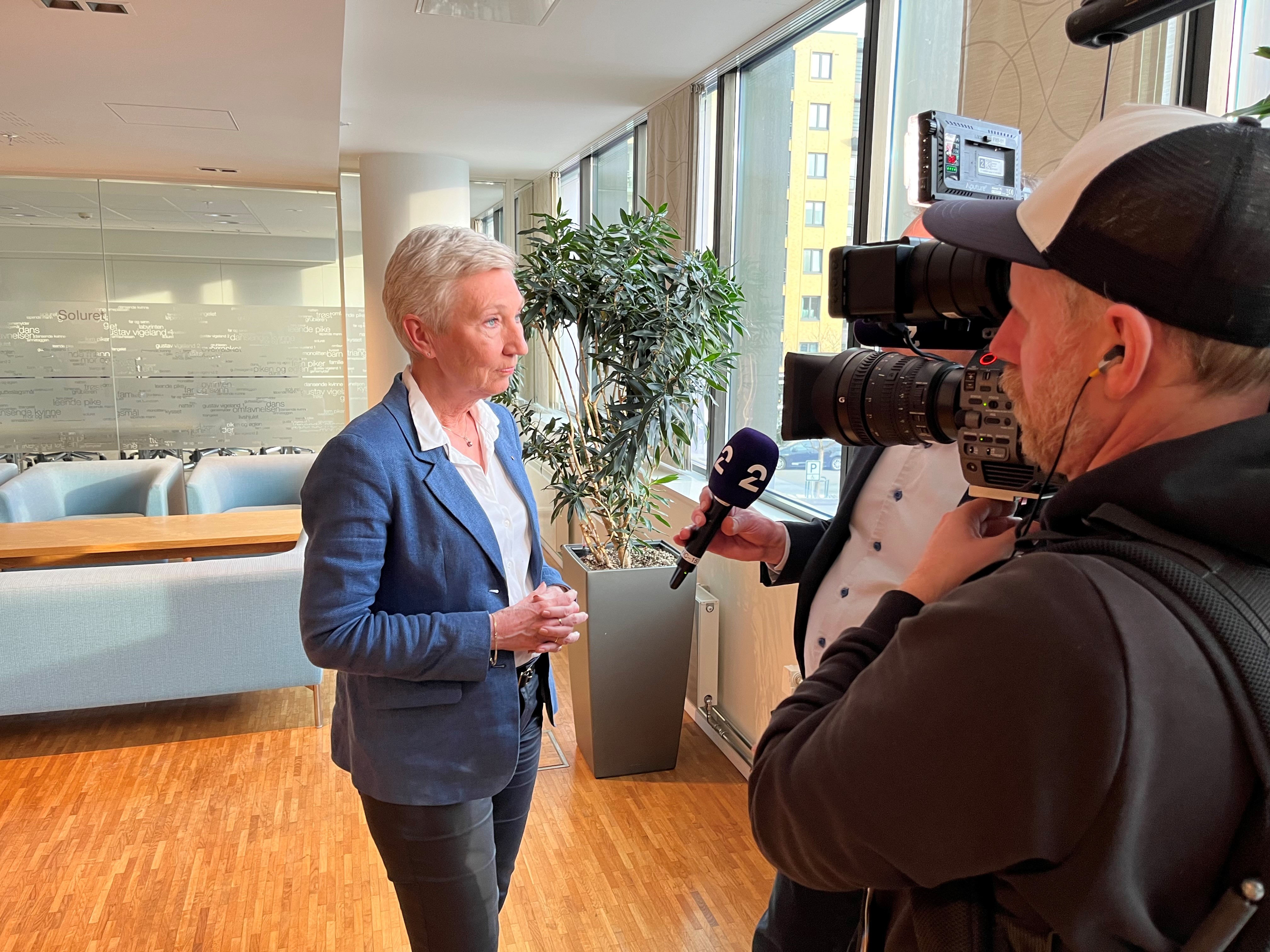 Bilde av LO-leder Peggy Hessen Følsvik  foran fagforeningsfaner.