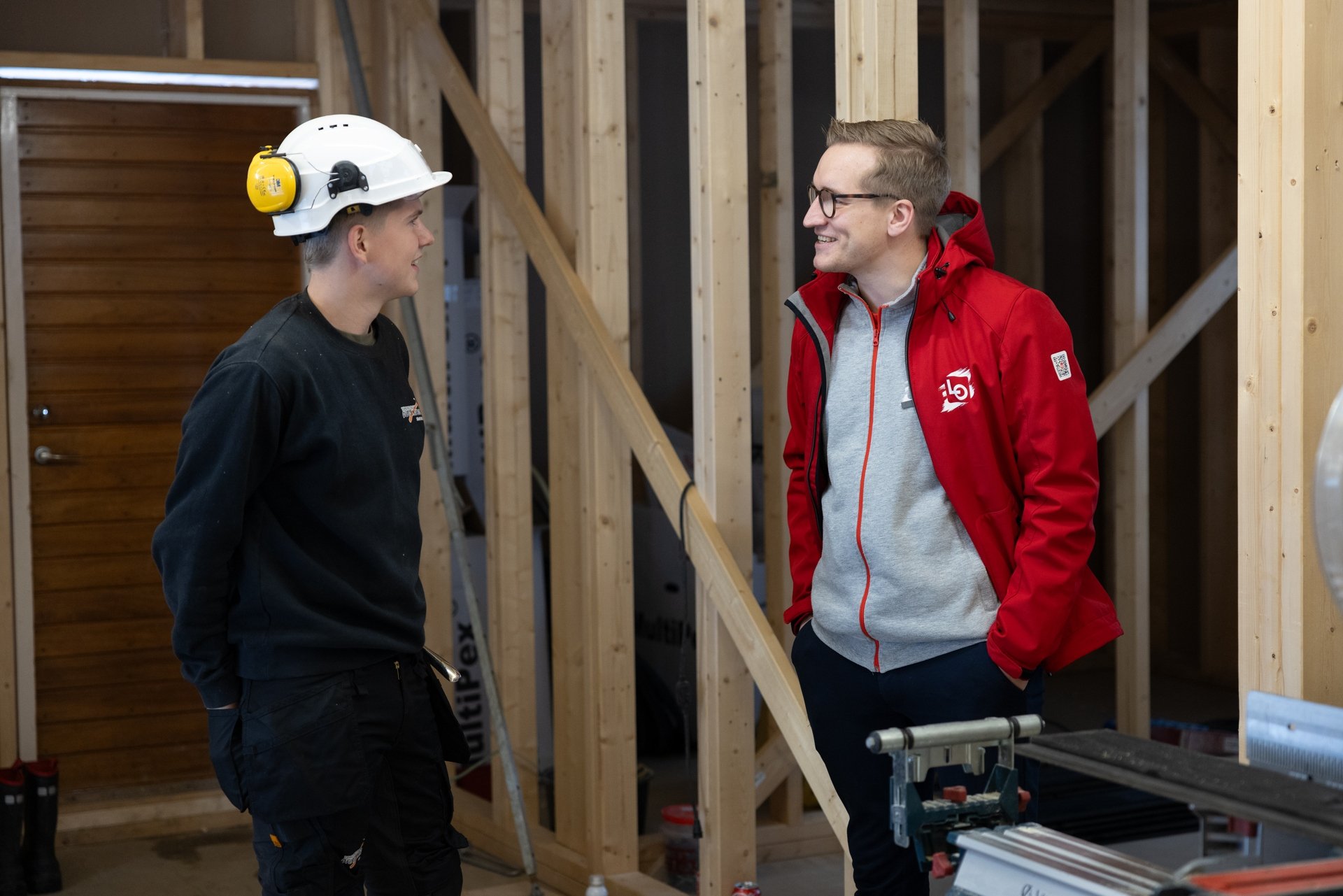Ung lærling med hjelm snakker med rådgiver fra LOs lærlingpatrulje. Foto.