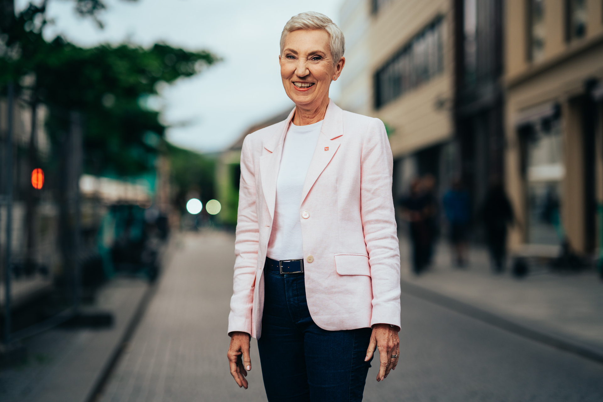 LO-leder Peggy Hessen Følsvik står ute i gaten og smiler til fotografen. Foto.