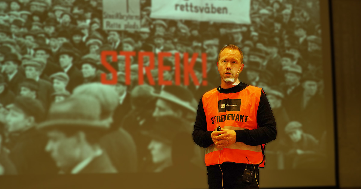 Jonas Bals i streikevest foran presentasjon av boka si "Streik" 