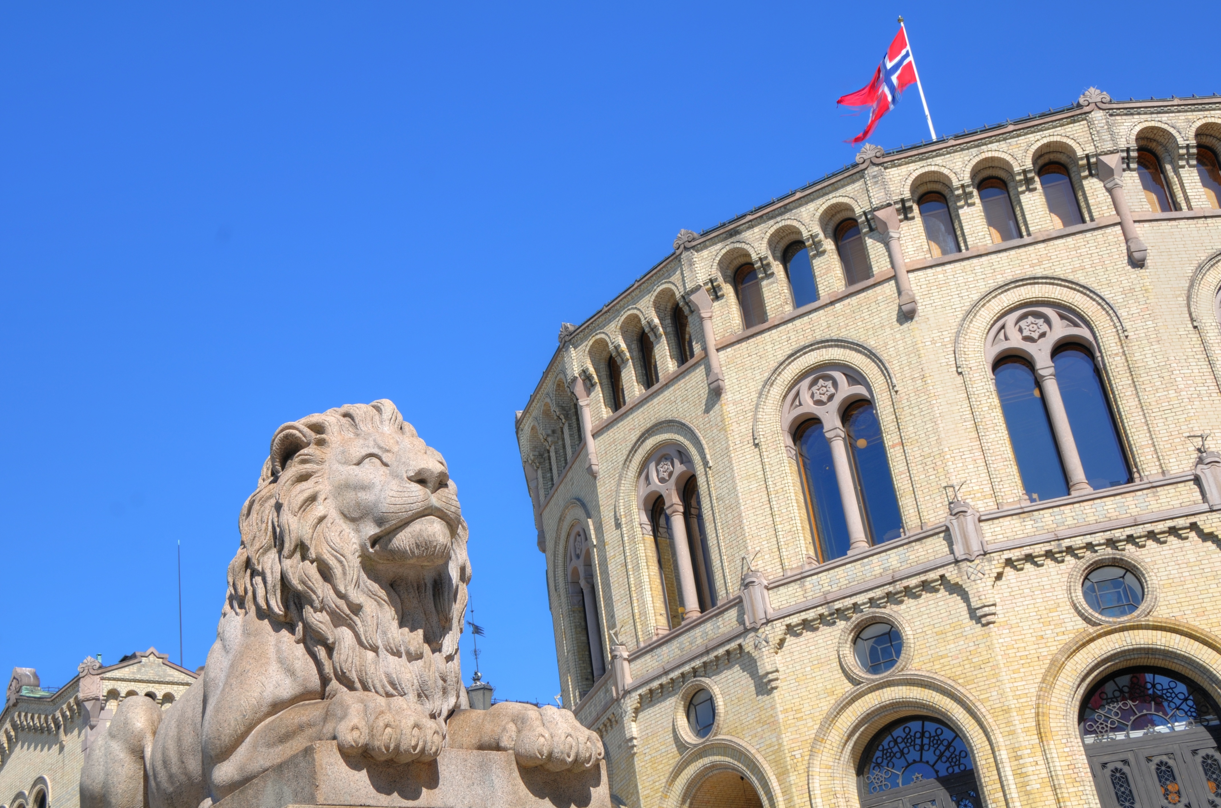 Bildet av Stortinget med riksløven og et norgesflagg