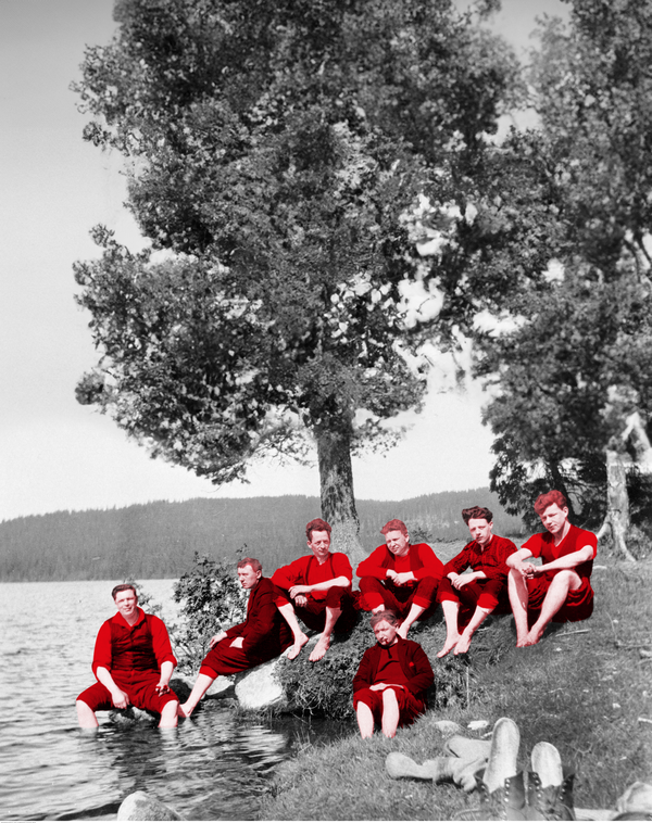 Bildet viser medlemmer av Turistklubben Gutenberg på pinsetur i Nordmarka i 1930. De sitter og slapper av ved et vann.