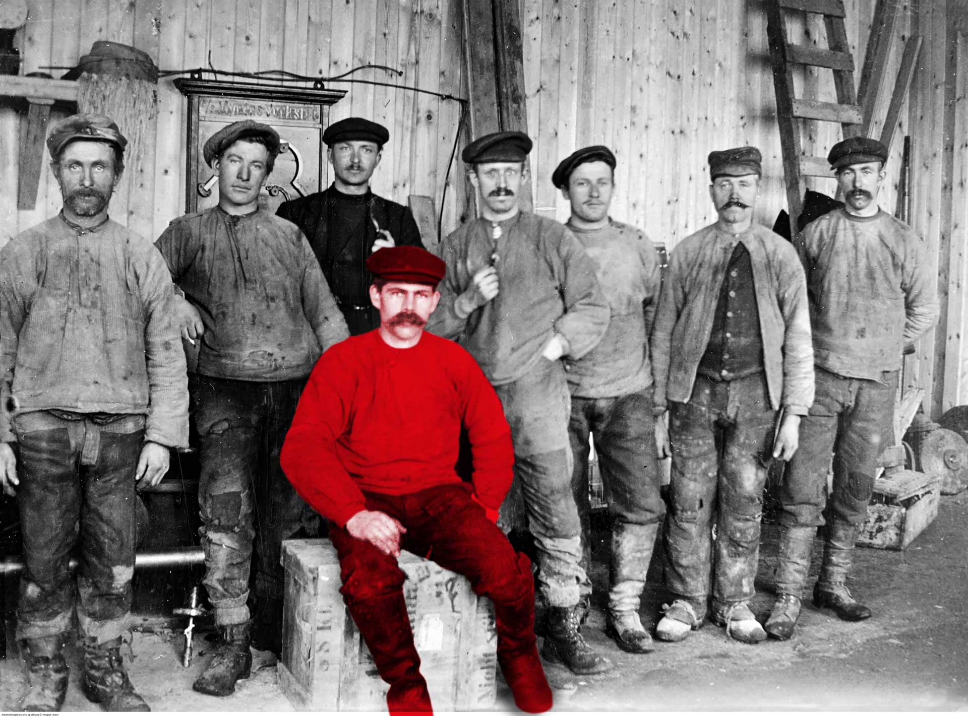 Bildet viser åtte arbeidere ved Myren verksted omkring 1900 til 1910. De er møkkete i ansiktet og klærne etter en lang arbeidsdag.