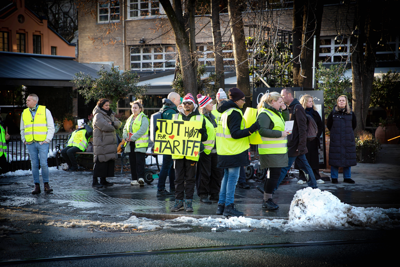 Bilder viser de ansatte på restauranten Olivia i Hegdehaugsveien i Oslo som streiker for tariffavtale. De er ikledd grønne refleksvester og står i snøslaps. En person holder et skilt hvor det står "tut for tariff".