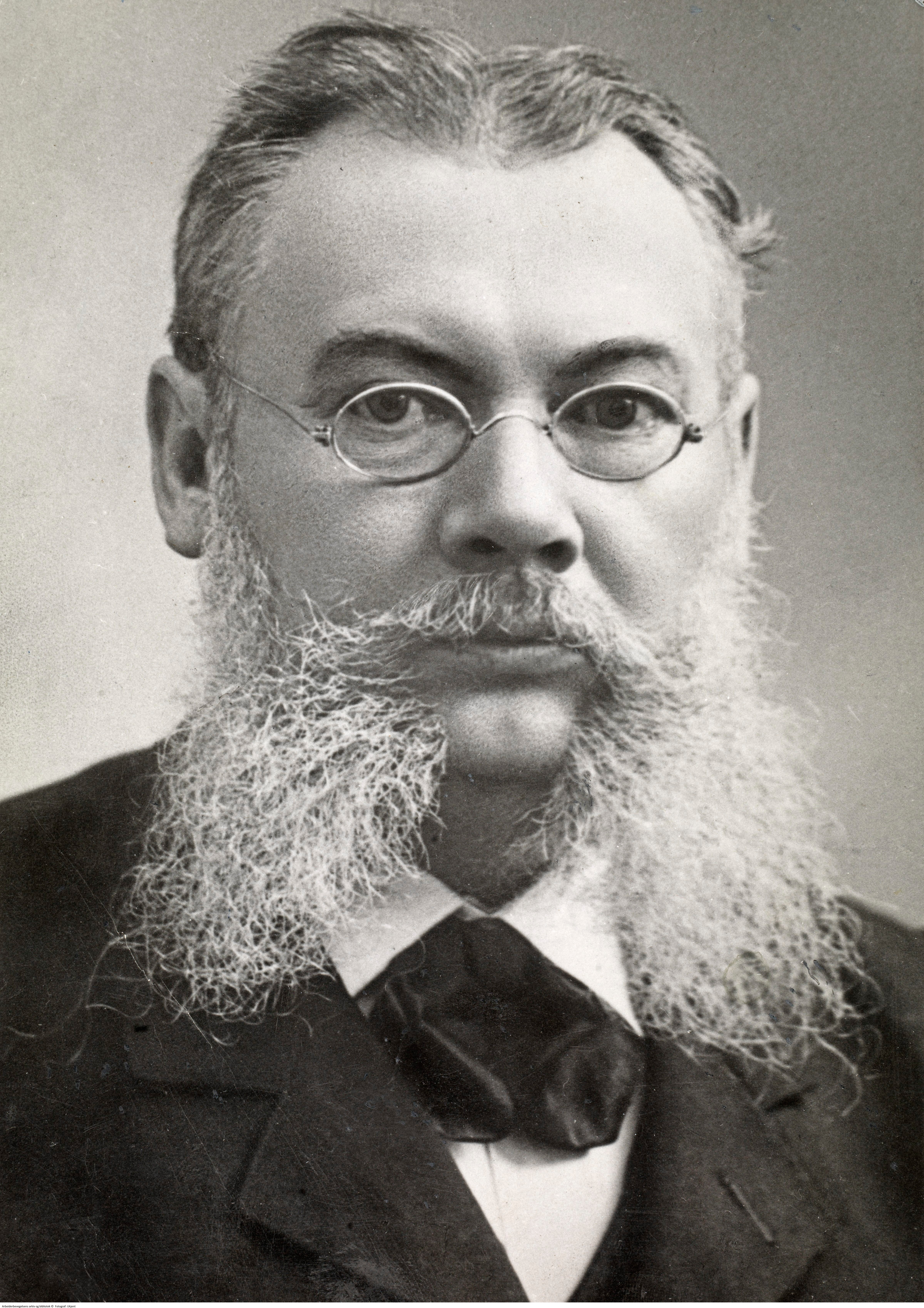 Bildet viser LOs første leder Hans Jensen, 1899. En eldre herremann med grått, pjuskete skjegg.